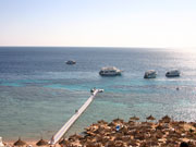 Egypte strand met parasols en boten in Sharm el Sheikh